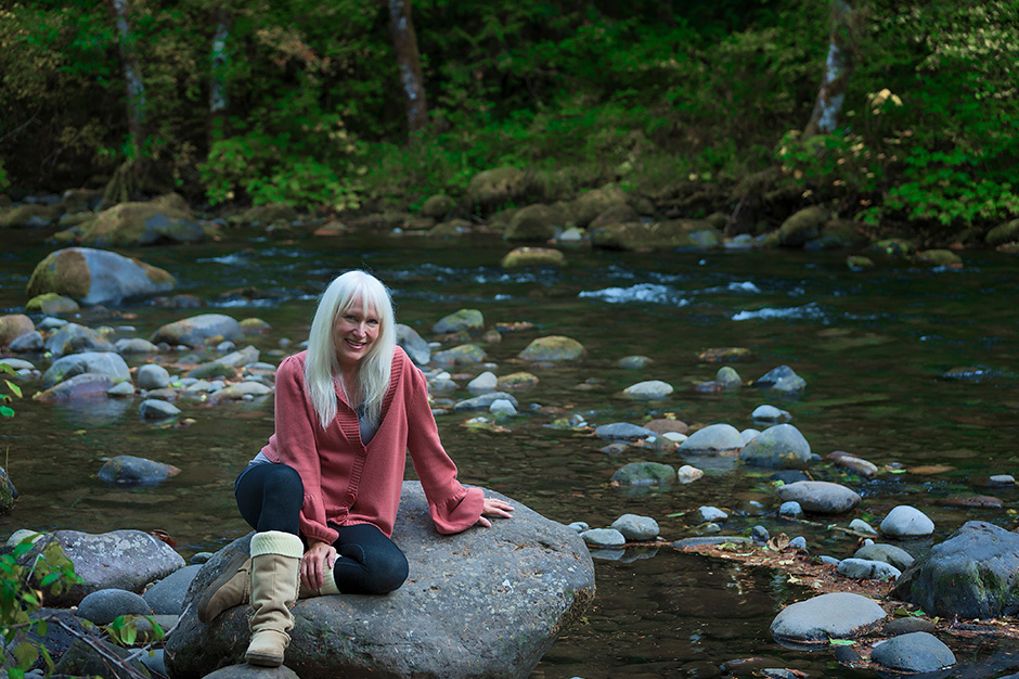 Woman sitting in a creek in the Pacific Northwest 