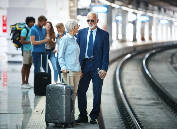 Older couple waiting by train tracks