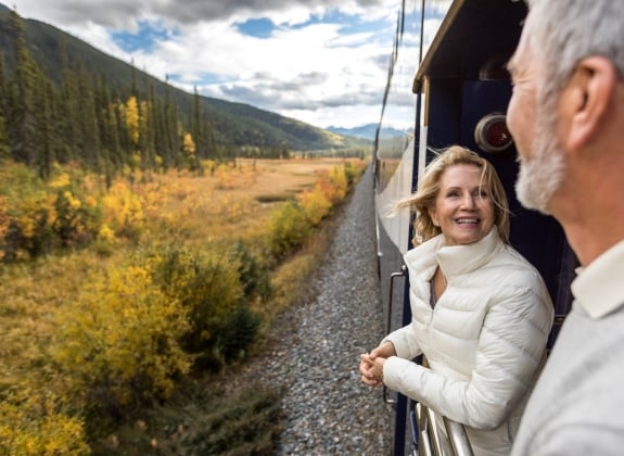 couple smiling on the GoldLeaf service platform on rocky mountaineer