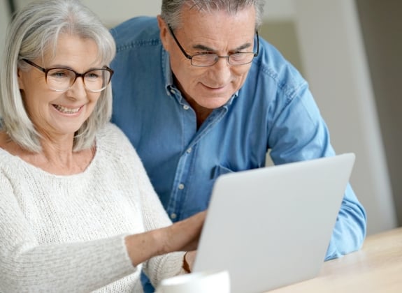 a happy couple on a computer planning their train trip