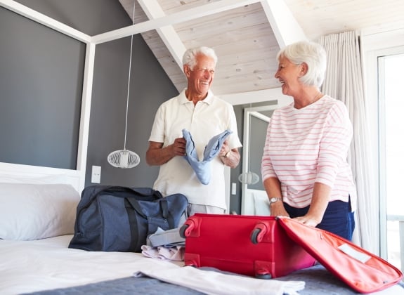 a happy couple packing suitcases