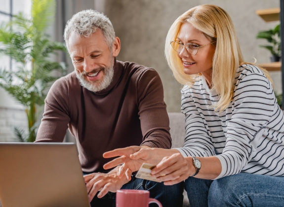 happy couple paying for a getaway online