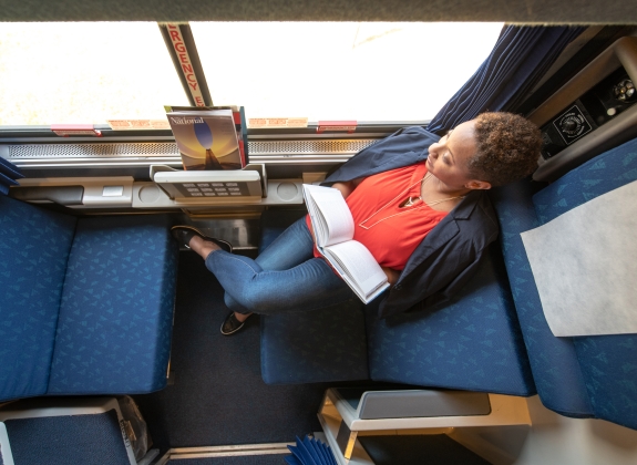 woman sitting in daytime layout of an Amtrak roomette