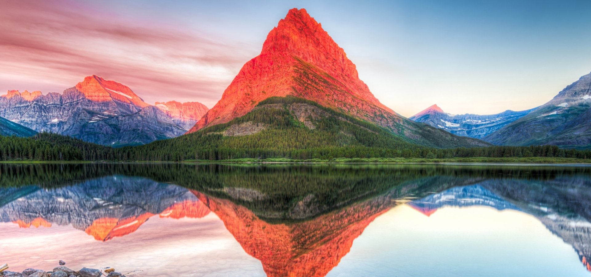 Stunning reflections on Swiftcurrent Lake in northern Montana at sunrise