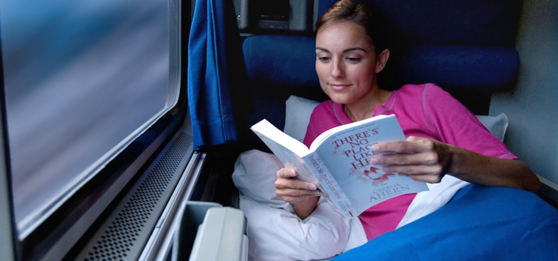 A Private Roomette onboard Amtrak a woman reading a book in a private Amtrak Roomette