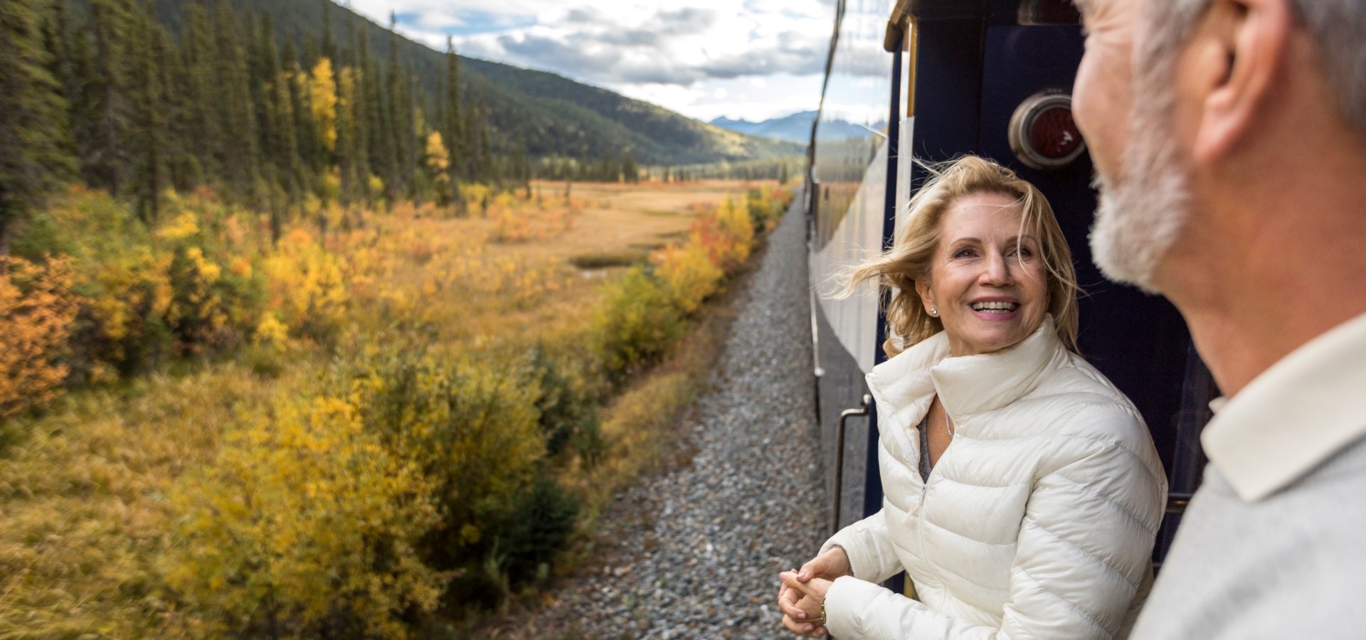 GoldLeaf Service Platform on Rocky Mountaineer couple smiling on the GoldLeaf service platform on rocky mountaineer