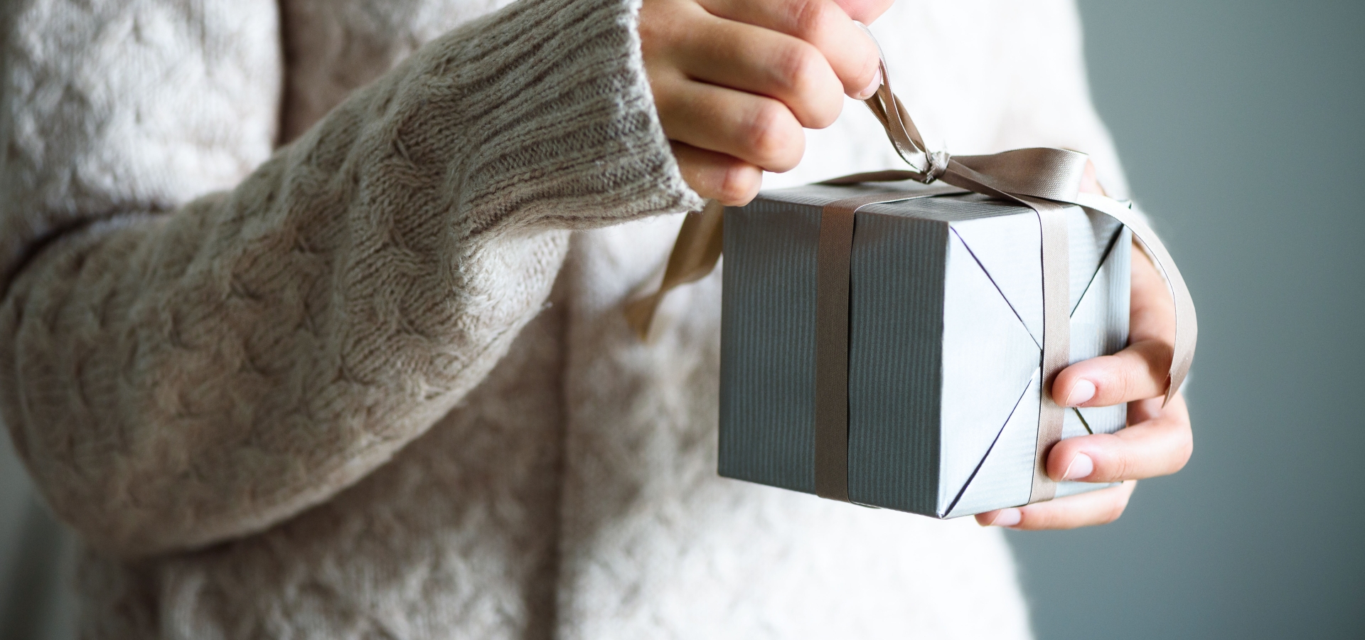 women's hands opening a gift box