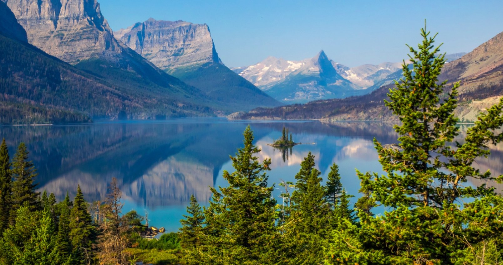 Goose Island in the middle of the St. Mary's lake with mountains peaks and reflection on background in Glacier National Park, Montana.