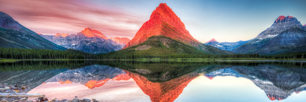Destination-Glacier-National-Park Stunning reflections on Swiftcurrent Lake in northern Montana at sunrise