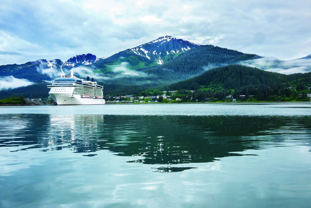 Cruise ship at a port in Juneau, Alaska with snow capped mountain and low lying fog in the background