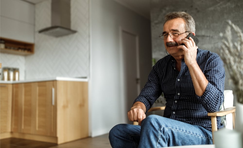 Contact Us man sitting in room on phone