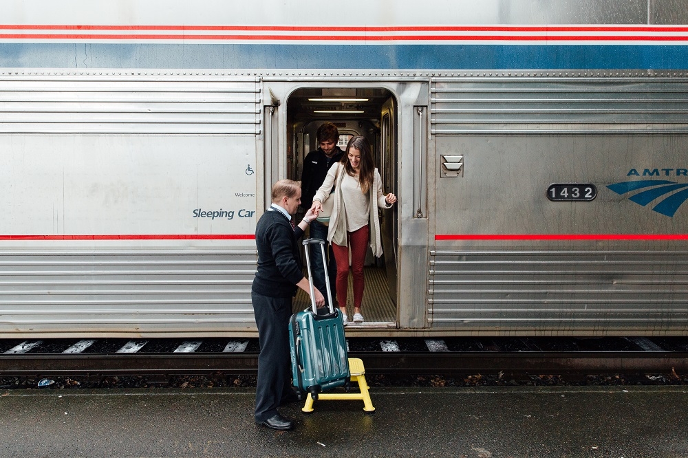 Woman being helped with luggage Amtrak